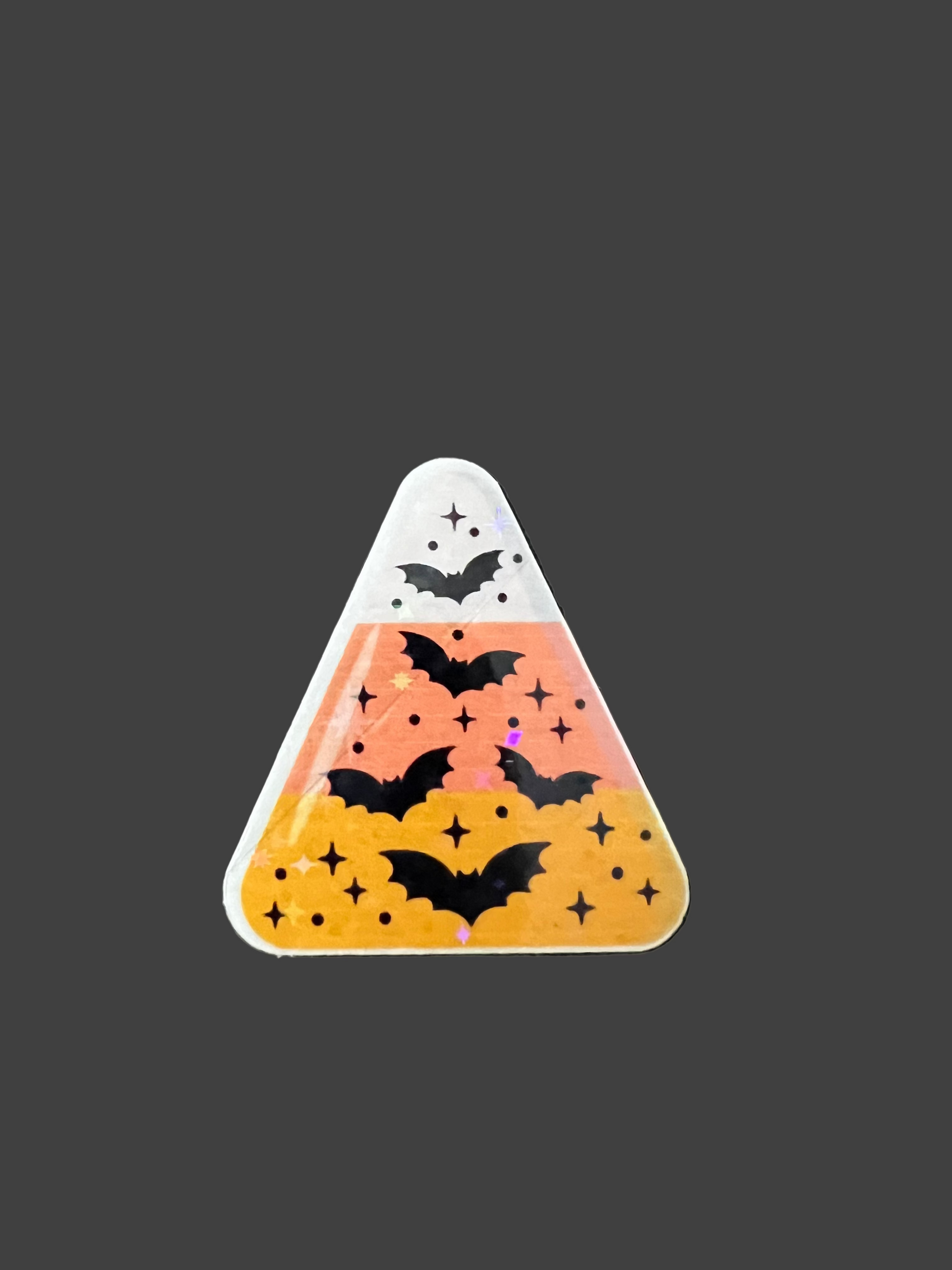 Halloween-themed candy corn-shaped sticker with bats and stars on a black background