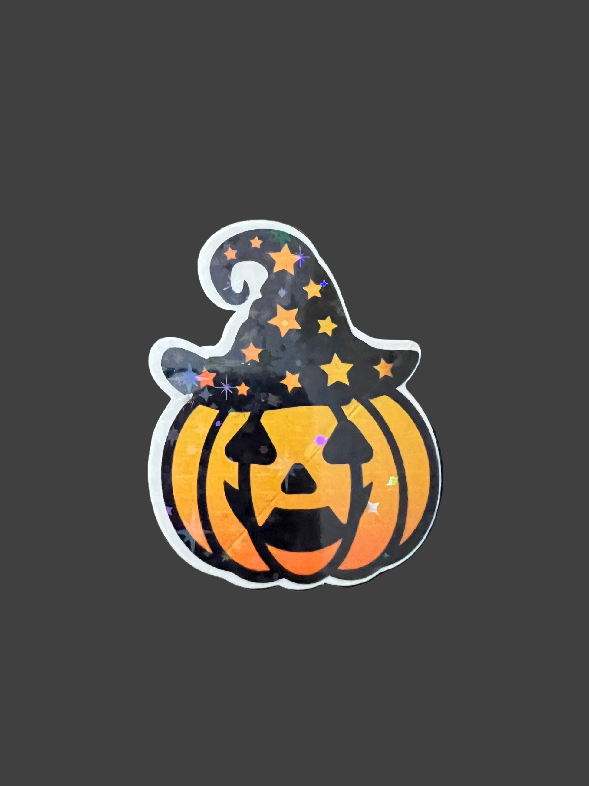 Halloween-themed sticker of a pumpkin with a witch hat on a dark background