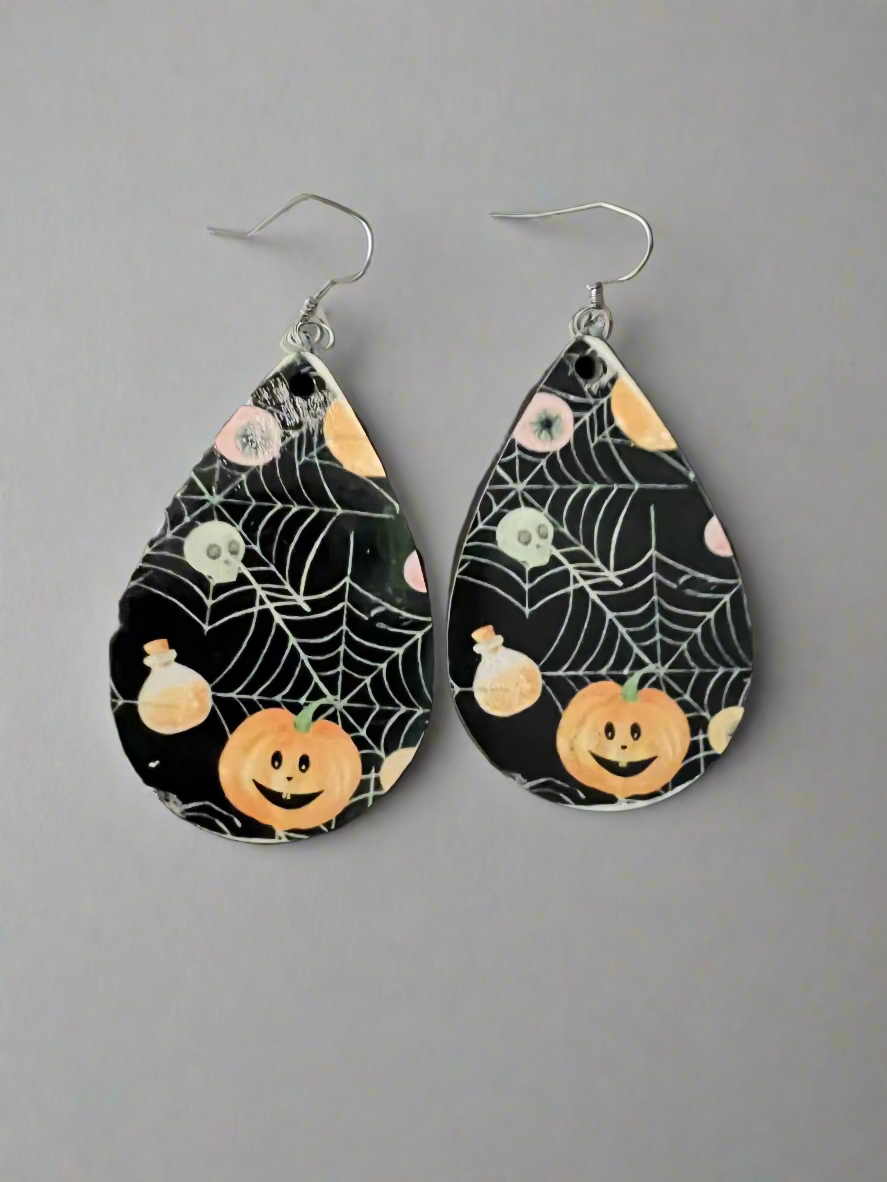 Teardrop-shaped Halloween-themed earrings on a black background
